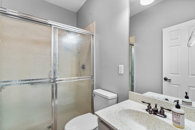 bathroom featuring toilet, vanity, and walk in shower