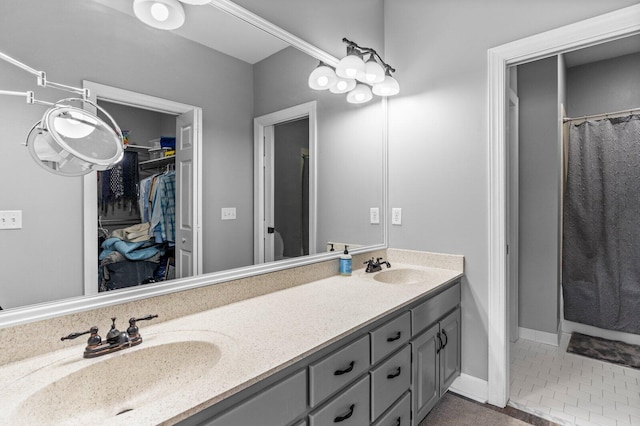 bathroom featuring tile patterned flooring, vanity, and walk in shower