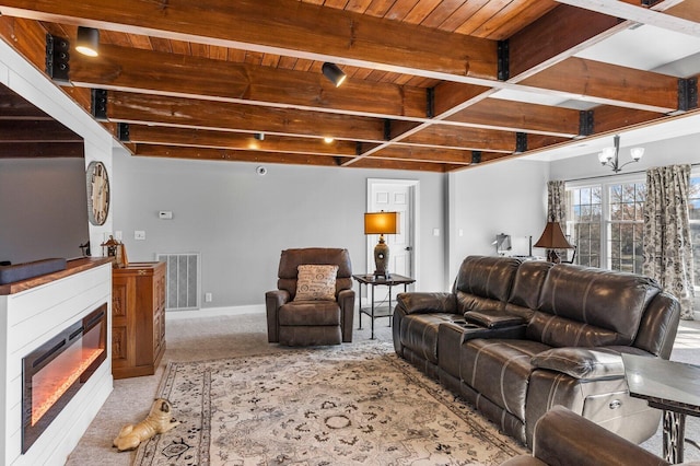 carpeted living room featuring a notable chandelier, beam ceiling, and wooden ceiling