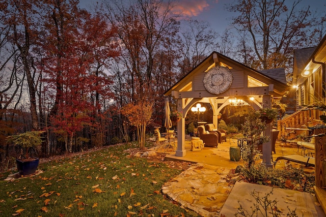 yard at dusk featuring an outdoor hangout area and a patio