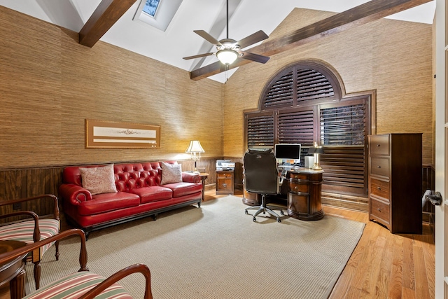 office area with a skylight, ceiling fan, wood-type flooring, high vaulted ceiling, and beamed ceiling