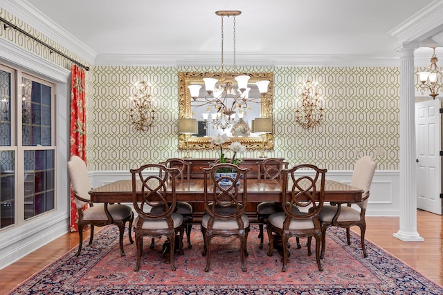 dining room featuring hardwood / wood-style floors, ornate columns, and ornamental molding