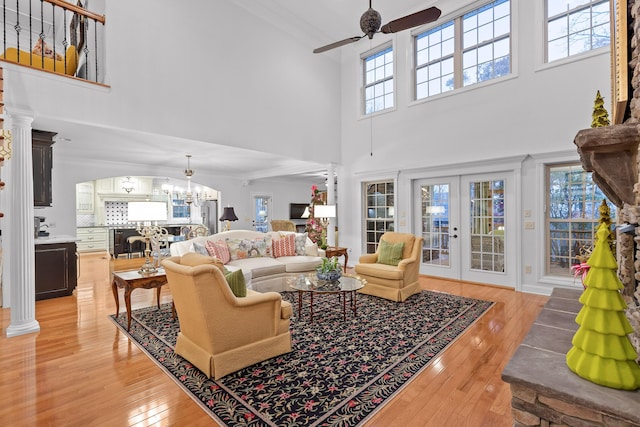 living room with plenty of natural light, french doors, a high ceiling, and light hardwood / wood-style flooring