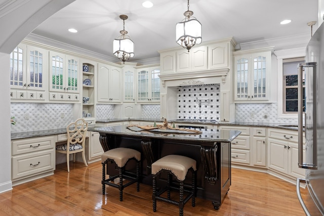 kitchen with ornamental molding, a center island, light hardwood / wood-style flooring, and a breakfast bar area