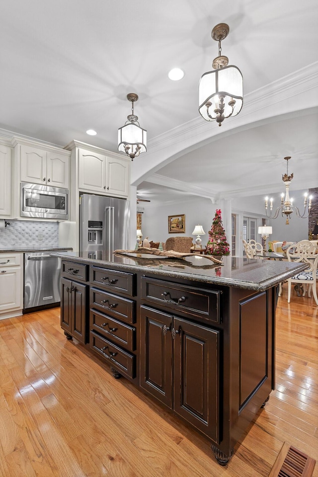 kitchen with white cabinets, stainless steel appliances, light hardwood / wood-style flooring, and ornamental molding