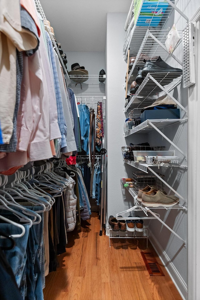 walk in closet with wood-type flooring