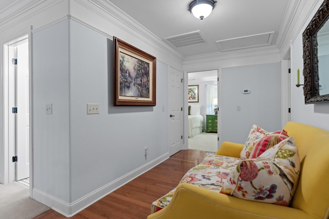 sitting room with wood-type flooring and ornamental molding