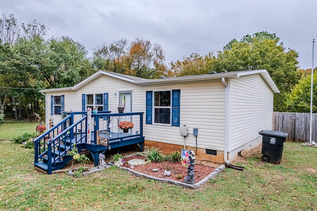 rear view of property with a lawn and a wooden deck