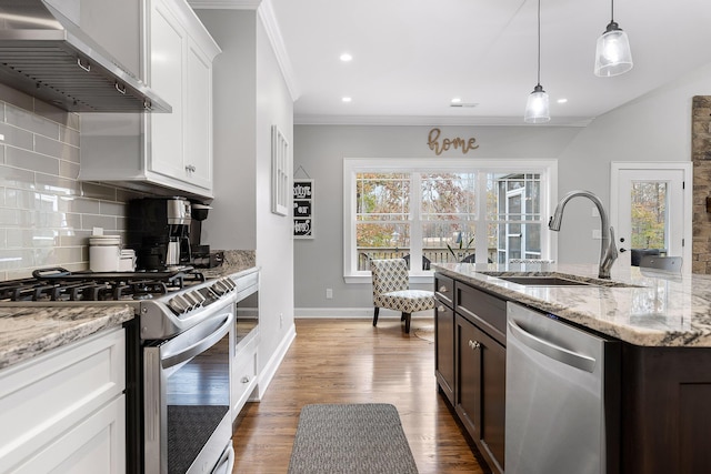 kitchen with wall chimney exhaust hood, light stone counters, stainless steel appliances, and white cabinetry