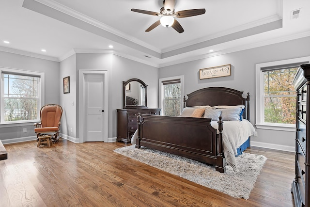 bedroom featuring ceiling fan, a raised ceiling, and ornamental molding