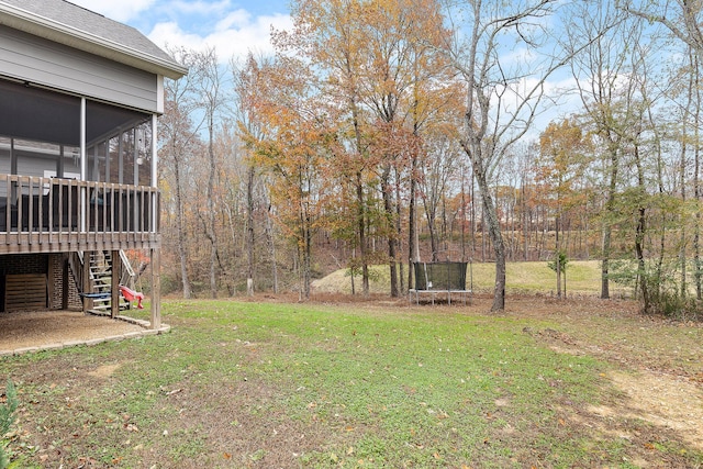 view of yard featuring a trampoline and a sunroom