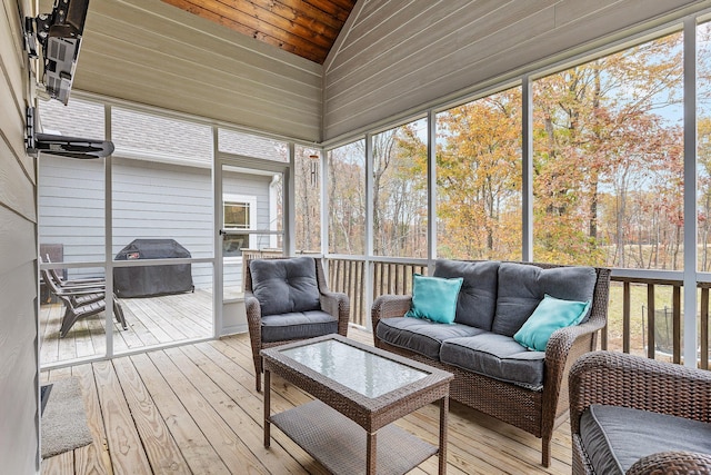 sunroom / solarium featuring vaulted ceiling, wooden ceiling, and plenty of natural light