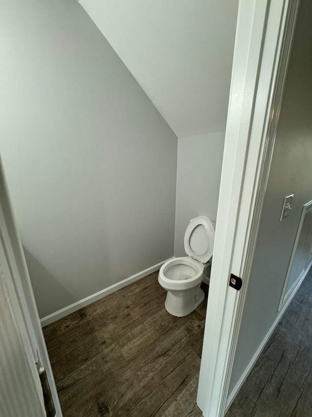 bathroom featuring hardwood / wood-style flooring, toilet, and lofted ceiling