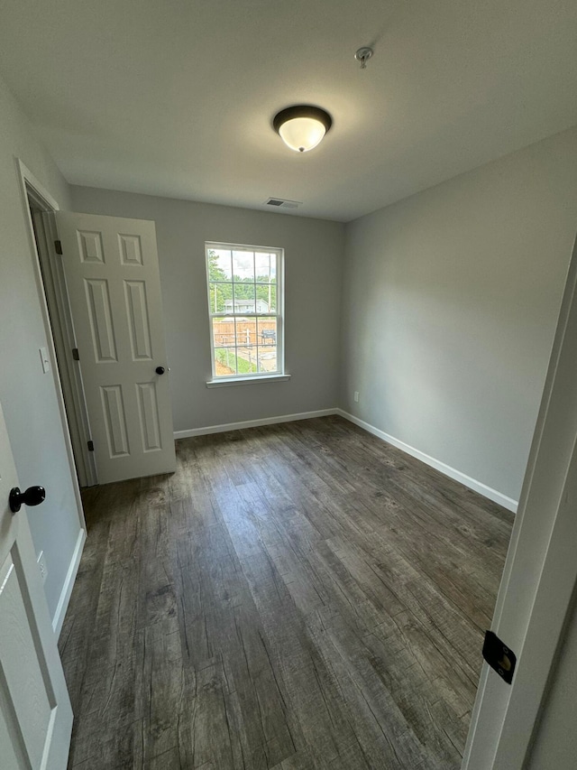 unfurnished room featuring dark wood-type flooring