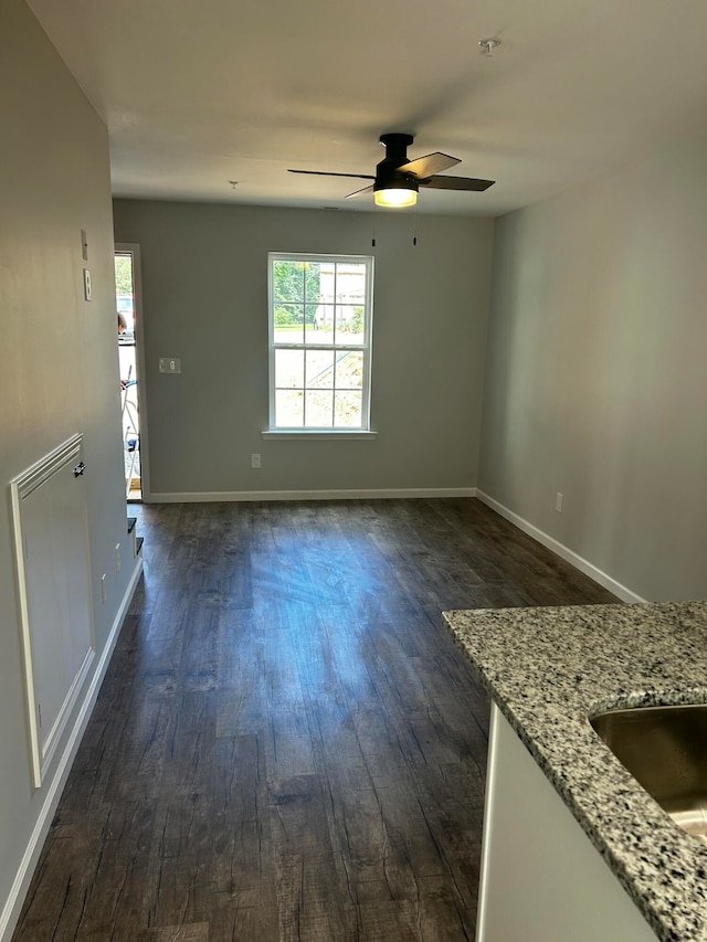 empty room with ceiling fan and dark wood-type flooring