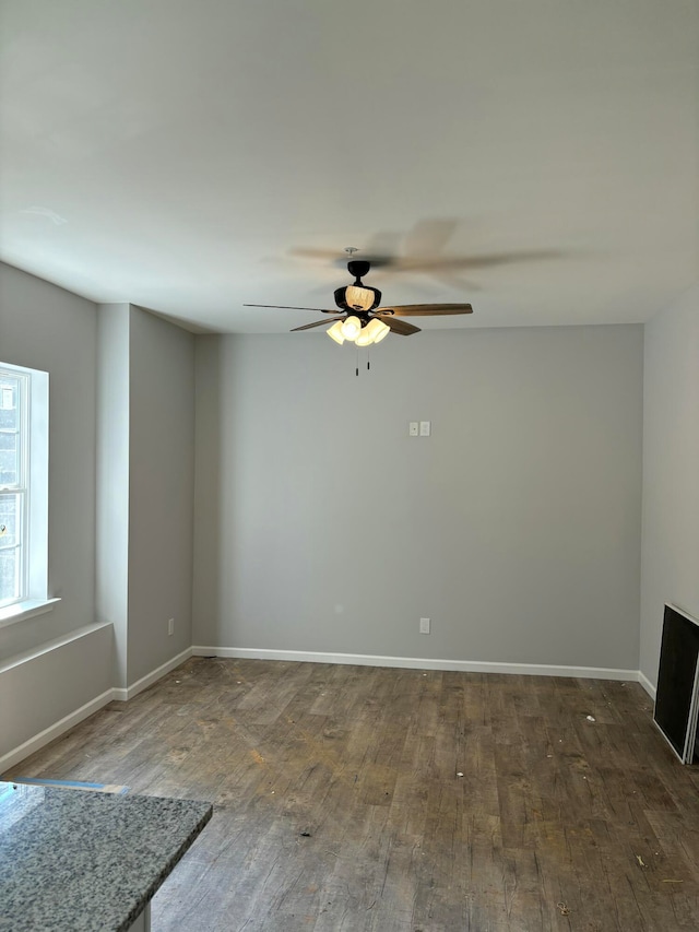 spare room featuring dark hardwood / wood-style flooring and ceiling fan