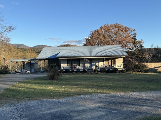 view of front of house featuring a mountain view, a porch, and a front lawn