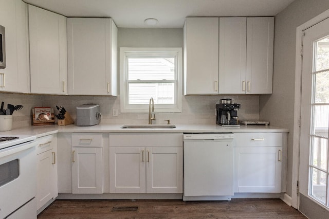 kitchen with white appliances, dark wood-type flooring, sink, decorative backsplash, and white cabinetry