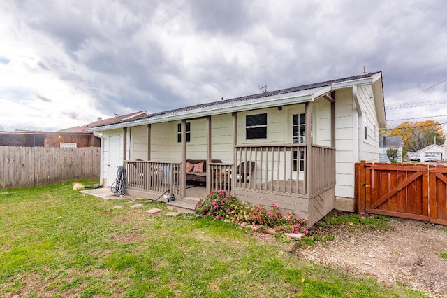 rear view of property featuring a lawn