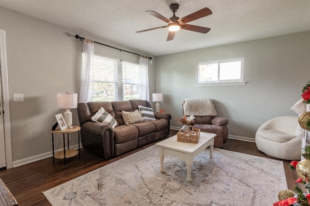 living room featuring ceiling fan, dark hardwood / wood-style flooring, and a textured ceiling