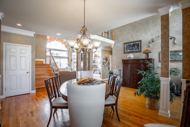 dining space with a chandelier, light wood-type flooring, and crown molding