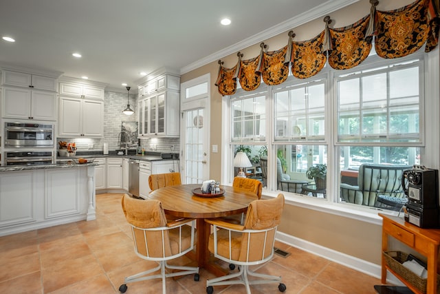 tiled dining space with crown molding and sink