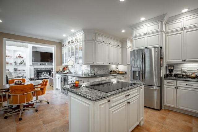 kitchen featuring stainless steel fridge with ice dispenser, a high end fireplace, dark stone countertops, black electric cooktop, and white cabinets