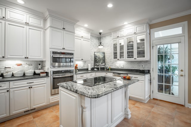 kitchen featuring black electric stovetop, white cabinets, double oven, tasteful backsplash, and a kitchen island