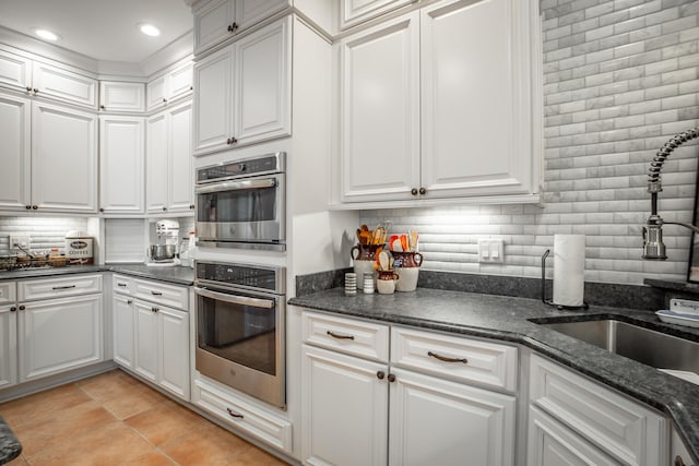 kitchen featuring backsplash, sink, and white cabinets