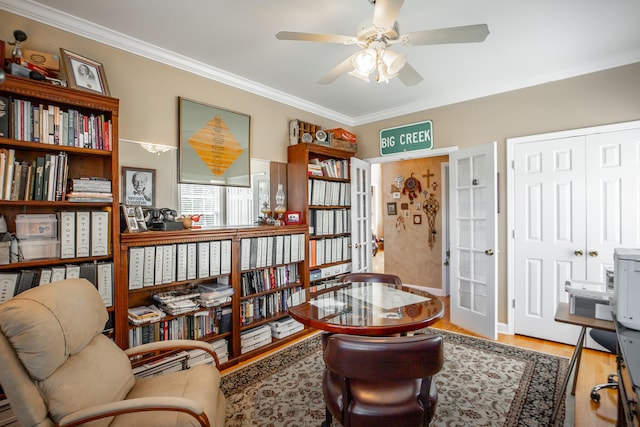 sitting room featuring ceiling fan, wood-type flooring, and ornamental molding