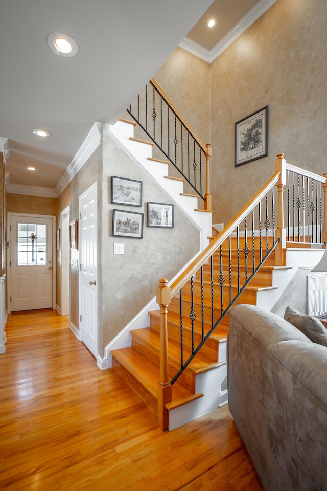 staircase featuring hardwood / wood-style floors and ornamental molding