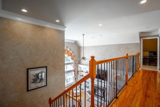 corridor with ornamental molding and hardwood / wood-style flooring