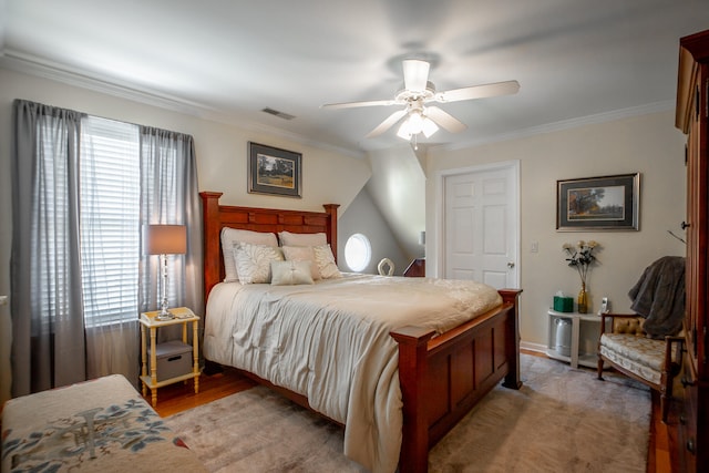 bedroom with ceiling fan, crown molding, and light hardwood / wood-style flooring