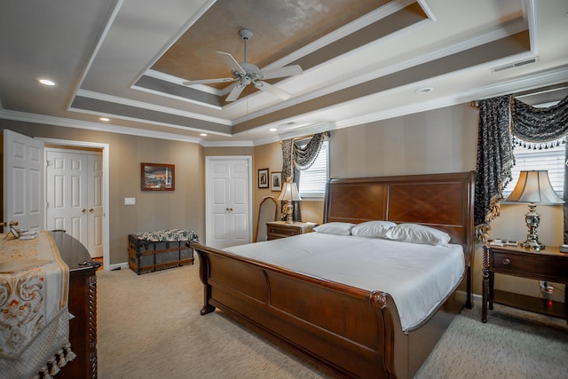 bedroom with a tray ceiling, ceiling fan, crown molding, and light colored carpet