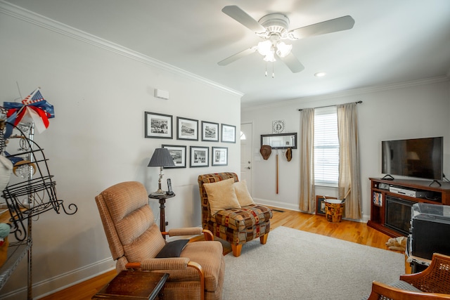 living area with light wood-type flooring, ceiling fan, and ornamental molding