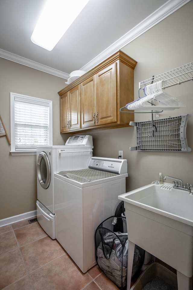 washroom with cabinets, sink, washer and dryer, ornamental molding, and light tile patterned floors