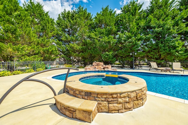 view of pool featuring an in ground hot tub