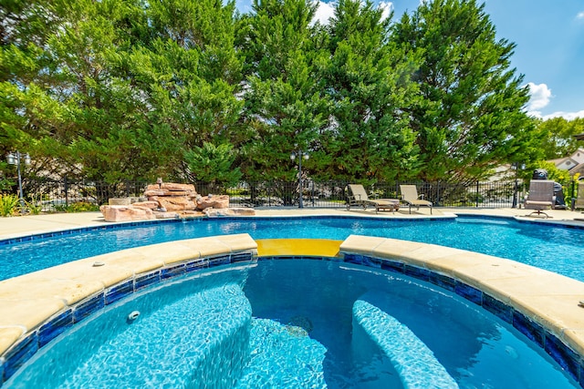 view of swimming pool with an in ground hot tub