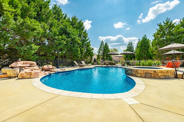 view of pool with a patio area and an in ground hot tub