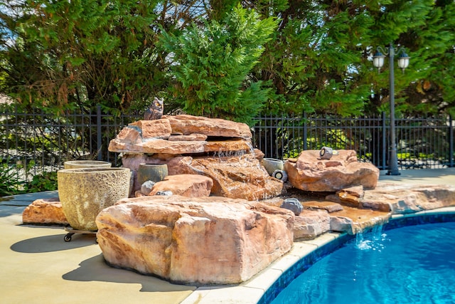 view of swimming pool with pool water feature