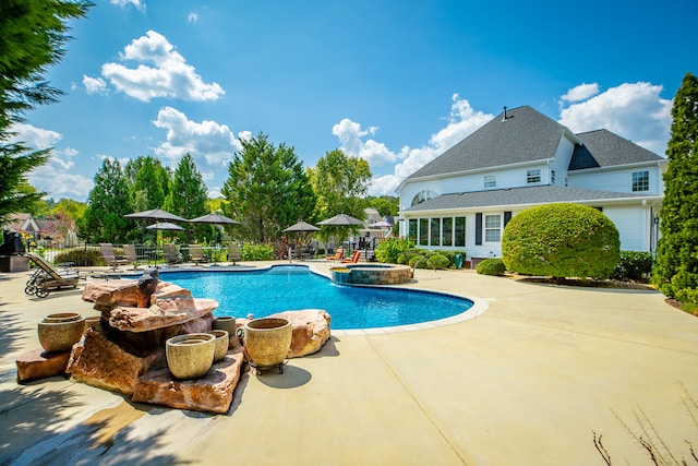 view of pool featuring a patio area and an in ground hot tub