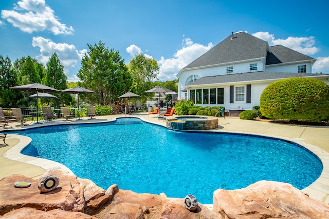 view of swimming pool featuring pool water feature, a patio area, and an in ground hot tub