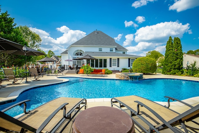 view of swimming pool with an in ground hot tub, pool water feature, and a patio area