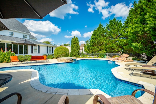 view of swimming pool with a patio area and an in ground hot tub