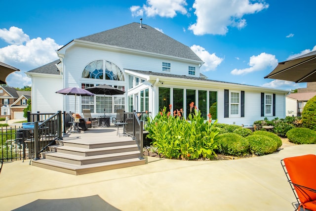 back of house featuring a sunroom and a deck