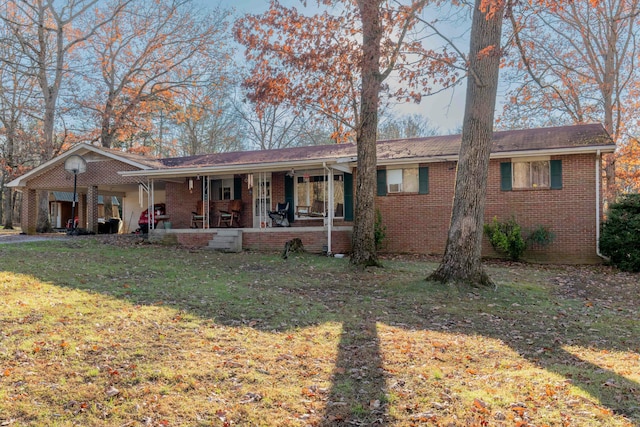 ranch-style house featuring a front lawn and covered porch