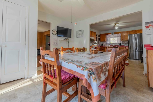 dining space featuring ceiling fan and sink