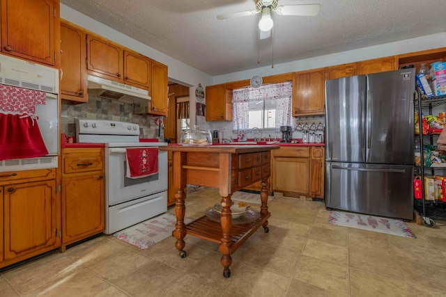 kitchen featuring ceiling fan, decorative backsplash, white appliances, and a textured ceiling