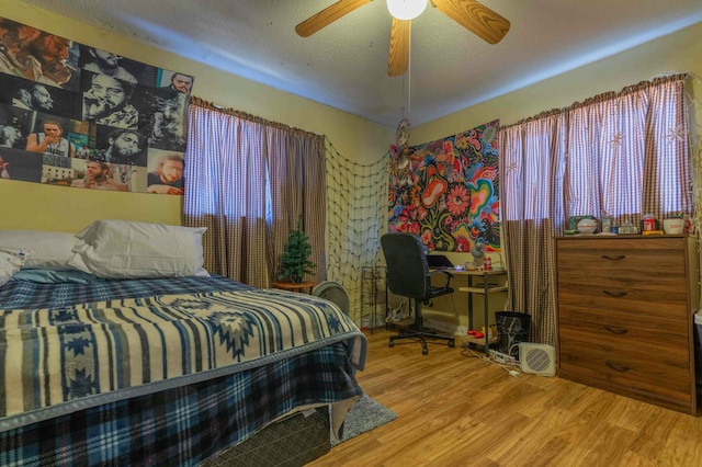 bedroom with ceiling fan, a textured ceiling, and hardwood / wood-style flooring