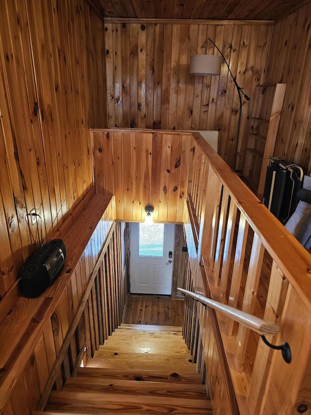 stairway with wood walls and hardwood / wood-style floors